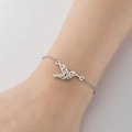 Elegante zilveren roestvrijstalen armband met kolibrie hanger aan vrouwenpols - Stalen Vogel