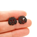 Macro shot of black tiger head stud earrings on fingertips showing small size - Tiger / Lion Head (687) / Black