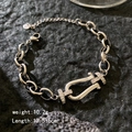 Silver horseshoe buckle bracelet with cubic zirconia and heart charm on black background - Oval Horseshoe Buckle / Silver - Oval Horseshoe