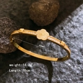 Golden titanium steel bangle with laser flower motif and cubic zirconia inlay - Gold