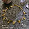 Goldenes Kleeblatt Armband mit hohlen Anhängern auf einer dunklen Steinoberfläche - Gold Hohl Kleeblatt Fußkettchen