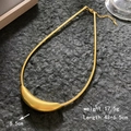 Gold minimalist snake chain necklace with curved bar pendant on a textured dark rock background - Curved Tube Lobster Clasp / Gold