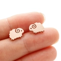 Cute minimalist sheep stud earrings in rose gold finish held on a finger for scale - Sheep (372) / Rose Gold