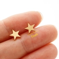 Macro shot of gold star stud earrings measuring 7mm diameter held by hand - 7mm / Gold