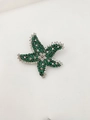 Detailed macro view of the starfish brooch with green and white pavé-set gemstones - Emerald Green
