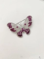 Gedetailleerde opname van een zilveren vlinderbroche met roze en witte edelstenen op wit - Letter B