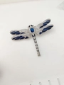 Dettaglio di una spilla a libellula in argento con zirconi blu e ali intarsiate - Blu
