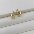 Dettaglio di orecchini a C placcati in oro con micro pavé di zirconi e finitura lucida a specchio - Oro