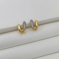 Dettaglio di orecchini a U dorati asimmetrici con cristalli di zirconia micro-pave - Due colori