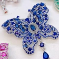 Macro-opname van de fonkelende blauwe zirkoon vlinderbroche met een druppelvormige hanger - Blauw