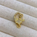 Gros plan d'un fermoir mousqueton doré avec zircons pour la création de bijoux - B2 Or
