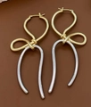 Elegant two-tone gold and silver bow-shaped knot drop earrings on brown background - Irregular Streamline Knot Dangle (Double Color 1)
