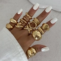 Detail view of gold metal rings set with irregular liquid textures and cross designs - Minimalist Signet Gold Style (6380)
