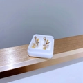Detailansicht der goldenen Titan-Blumenohrringe mit Zirkonia-Steinen in weißer Box - Gold Schmetterling Reihe Zirkonia Stil