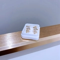 Makro-Detail vergoldeter Blatt-Ohrstecker mit drei klaren Steinen im Marquis-Schliff - Gold Drei Steine Reihe Zirkonia Stil
