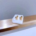 Makroaufnahme goldener Schmetterlings- und Bienenohrringe mit Zirkonia auf weißem Ständer - Gold Blauer Schmetterling