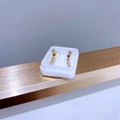 Makroansicht goldener gebogener Ohrstecker mit funkelnden Zirkonsteinen auf weißem Display - Gebogene Reihe Zirkonia / Gold Herz Diamant Pavé