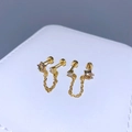 Nahaufnahme goldener Kettenohrringe mit Sternformen und bunten Zirkonia-Details - Stern Doppelpiercing / Gold