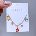 Detailaufnahme eines vergoldeten Bettelarmbands mit Emaille-Cartoons und glitzernden Steinen - Cartoon Kopf Herz Strass Armband (0716)