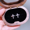 Nahaufnahme funkelnder Zirkon-Kreuz-Ohrstecker in einer edlen Geschenkbox aus Holz - Dornenkreuz