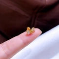 Makroaufnahme eines kleinen Schmetterlings-Ohrsteckers aus Gold mit Zirkonia-Herzen - Goldene Schleife