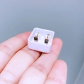 Detailaufnahme quadratischer schwarzer Zirkonia-Ohrstecker mit goldener Titanstahlbasis - Kleiner Würfel