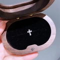 Glänzender Kreuz-Ohrstecker mit Zirkonia-Steinen auf schwarzem Samt präsentiert - Mikro-Pave-Kreuz