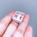 Makroaufnahme von kleinen goldenen Kugelohrringen auf der Hand mit poliertem Metall-Finish - 3mm Polierte Kugel
