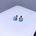Makroaufnahme hellblauer quadratischer Zirkonia-Ohrstecker mit goldener Titanbeschichtung - Vergoldet Aquamarin