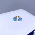Makroaufnahme von 8mm meerblauen Kristallohrringen mit vergoldeten Edelstahl-Schraubverschlüssen - Vergoldet Aquamarin