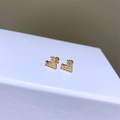 Makro-Detail herzförmiger goldener Ohrstecker mit Zirkonia-Inlay auf weißem Leder - Herz Zirkonia-Modell