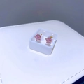 Nahaufnahme von rosa sternförmigen Zirkonia-Ohrringen mit goldenem Titanstahl-Sockel - Rosa Stern Zirkonia
