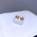 Makroaufnahme von goldenen Schleifen-Ohrsteckern mit weißen Zirkonia in weißer Box - Zirkonia-Schleife