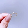 Nahaufnahme eines goldenen Wellenrings mit tropfenförmigem Opal-Edelstein in der Hand - Wellen Wassertropfen Opal (L44R3180)