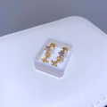 Detail von goldenen Sternohrringen mit Zirkonia-Besatz auf weißem Displayständer - Goldener Kreuzanhänger