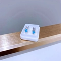 Makroaufnahme von Titanstahl-Ohrstecker mit himmelblauem Edelstein und klarem Zirkon - Silber Blau Zirkonia Blume