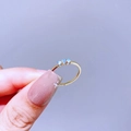 Nahaufnahme von drei hellblauen Edelsteinen in einem goldfarbenen offenen Ring - Hellblauer Cabochon Drei Hauptsteine (L41R4094 Blauer Opal)