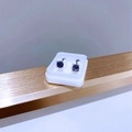 Makroaufnahme der lila Zirkonia Ohrstecker mit Vier-Klauen-Fassung aus Titanstahl - Platin Violetter Zirkonia