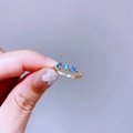 Detaillierte Makroansicht des vergoldeten Rings mit drei blauen Zirkoniasteinen und Perlenrand - Drei Blaue Saphire Nebeneinander (L33R4150)