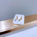 Makroaufnahme goldfarbener Ohrstecker mit weißen Kristallen und hellblauem Tropfenstein - Gold Blue Zircon Leaf