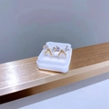 Vue détaillée de boucles d'oreilles papillon dorées avec zircones dans un écrin blanc - Nœud Goutte Doré