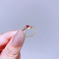Detailansicht eines goldnen Rings mit rotem Dreiecks-Edelstein auf lila Hintergrund - Dreieckiger Roter Hauptstein (L17R4295)