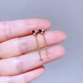 Detailaufnahme eines Schmetterling-Ohrrings mit blauen Zirkonia und goldenen Quasten - Gold Blue Zircon Butterfly Tassel