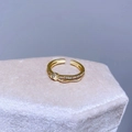 Dettaglio macro di un anello intrecciato placcato oro con zirconi bianchi su velluto - Stile Intrecciato Torsadé con Zircone (D54)