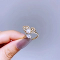 Close-up of golden butterfly ring with pearls and pear-shaped stone on a hand - Gold Teardrop Butterfly Style