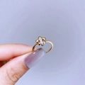 Detail of a gold adjustable ring featuring a four-petal white flower with twisted band texture - Gold Shell Flower Style
