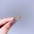 Detail of a gold-plated twisted open ring featuring delicate pave-set zircon stones - Gold Knot Style