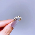 Detail of adjustable gold ring with inlaid white stars held between fingers - Gold Creamy White Star Style