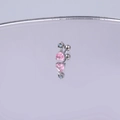 Detailansicht eines herzförmigen Ohrsteckers mit rosa Zirkon auf einer Spiegeloberfläche - Silber Rosa Blau Herz