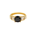 Primer plano de un anillo de titanio dorado con circonita negra y piedras laterales - US 7 / Negro